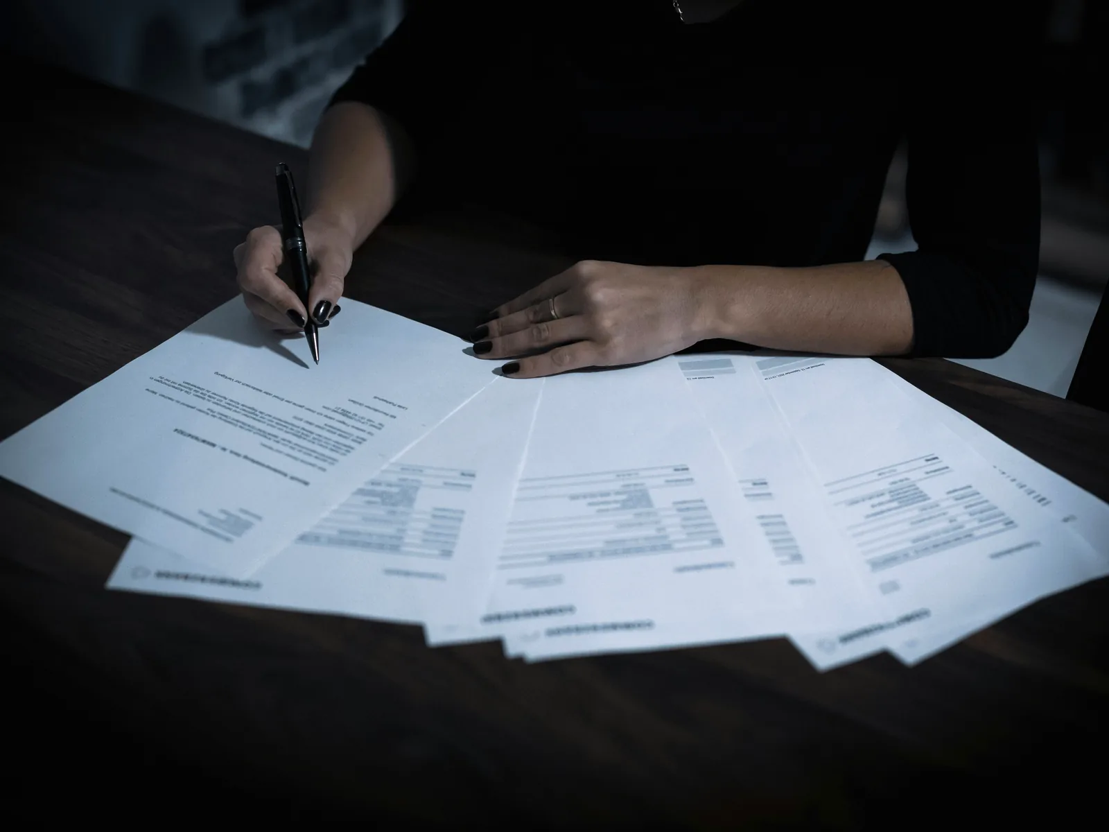 Printed invoices and forms being worked through by hand, the kind of repetitive document handling automation takes over