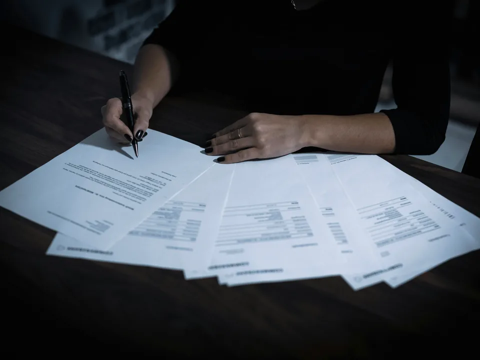 Printed invoices and forms being worked through by hand, the kind of repetitive document handling automation takes over